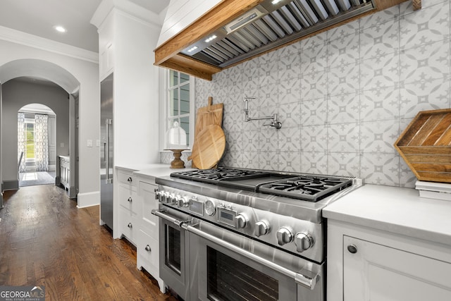 kitchen featuring tasteful backsplash, white cabinetry, range with two ovens, and custom exhaust hood