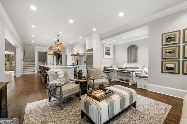 living room featuring dark hardwood / wood-style flooring, breakfast area, and ornamental molding