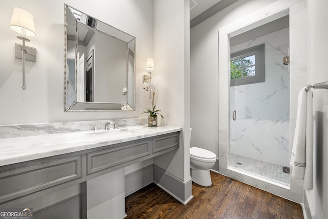 bathroom with vanity, toilet, an enclosed shower, and wood-type flooring