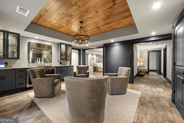 dining space with a raised ceiling, wood ceiling, and bar