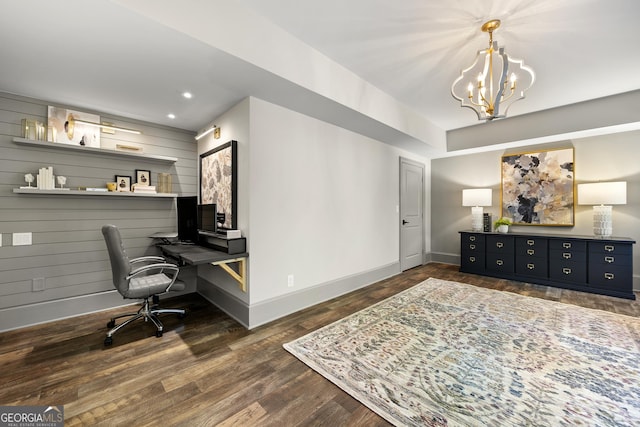 home office featuring wooden walls, built in desk, dark hardwood / wood-style floors, and a notable chandelier