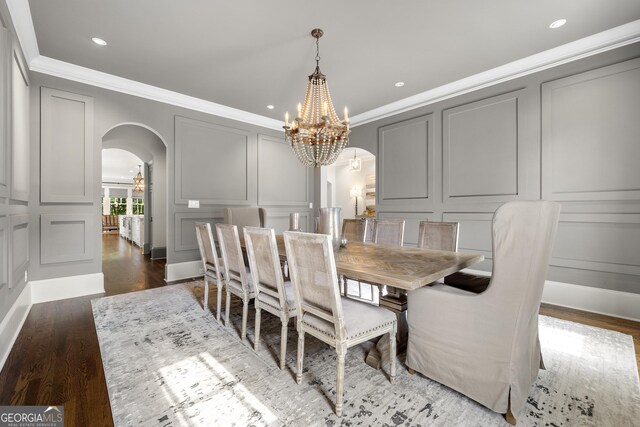 dining room with crown molding, dark hardwood / wood-style flooring, and a notable chandelier