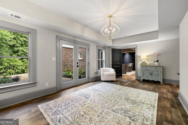 bedroom with dark wood-type flooring, french doors, access to outside, and a notable chandelier