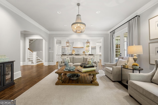 living room with crown molding, a notable chandelier, and hardwood / wood-style flooring