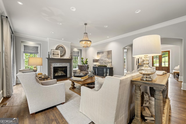 living room featuring crown molding, wood-type flooring, and a fireplace