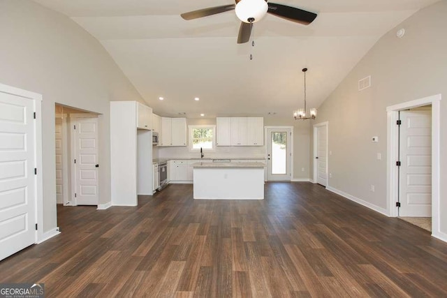 kitchen featuring pendant lighting, ceiling fan with notable chandelier, white cabinetry, and dark wood-type flooring