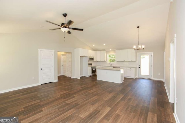 unfurnished living room featuring ceiling fan with notable chandelier, high vaulted ceiling, dark wood-type flooring, and sink