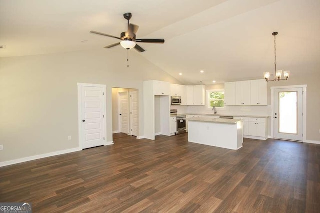 kitchen featuring dark hardwood / wood-style flooring, ceiling fan with notable chandelier, stainless steel appliances, a kitchen island, and white cabinetry