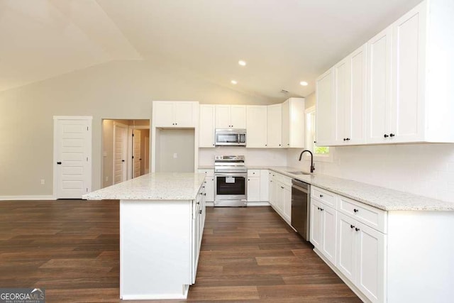 kitchen with white cabinetry, a kitchen island, vaulted ceiling, and appliances with stainless steel finishes