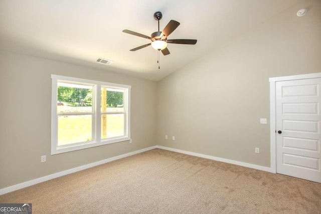 empty room featuring ceiling fan, lofted ceiling, and carpet floors