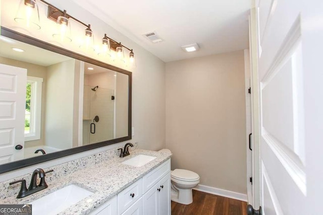 bathroom featuring hardwood / wood-style floors, vanity, toilet, and a shower with shower door