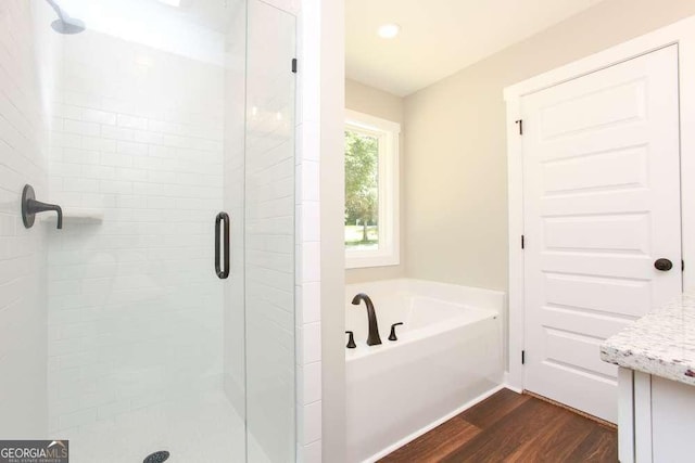 bathroom featuring hardwood / wood-style floors, vanity, and independent shower and bath