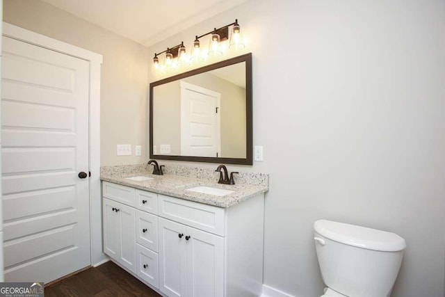 bathroom with wood-type flooring, vanity, and toilet