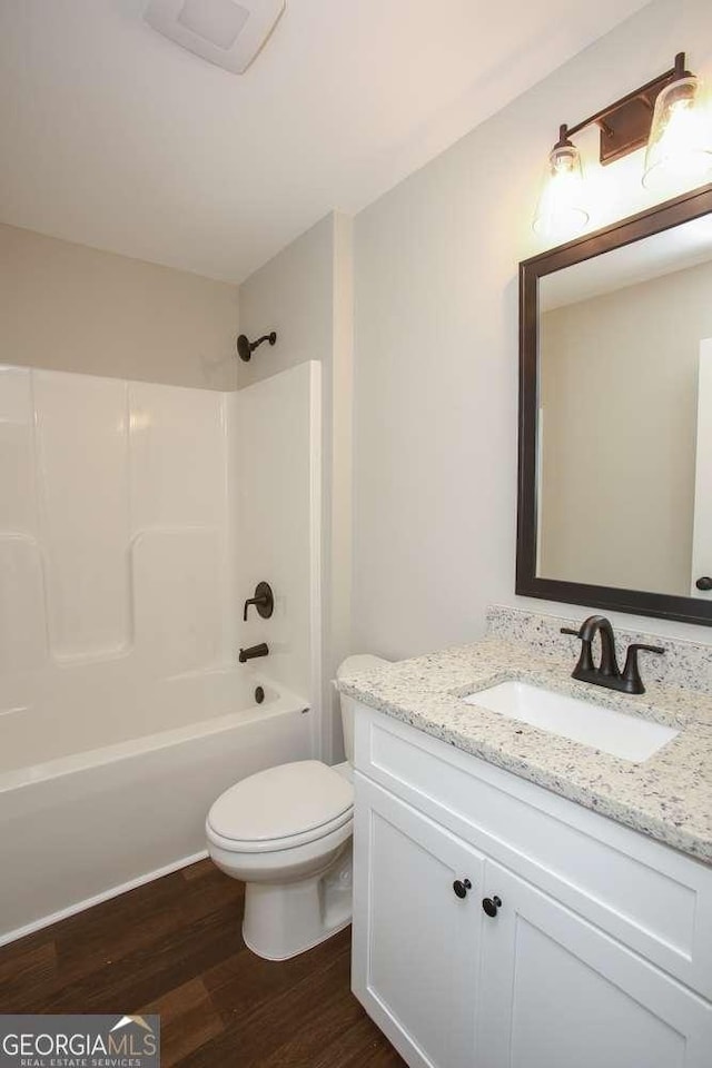 full bathroom with toilet, wood-type flooring, vanity, and bathing tub / shower combination