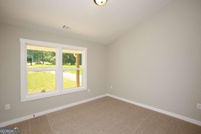 unfurnished room featuring carpet and lofted ceiling