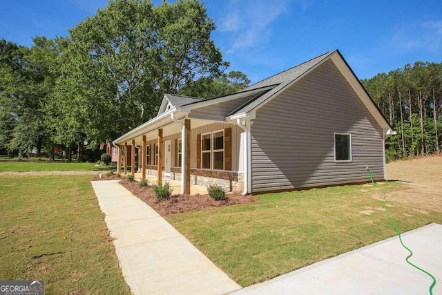 view of side of home featuring a porch and a yard