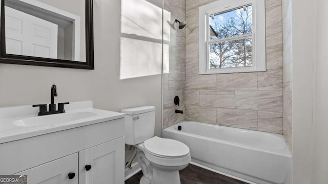 full bathroom with vanity, tiled shower / bath combo, and toilet