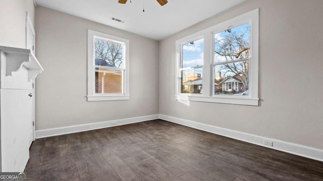 empty room with ceiling fan and dark wood-type flooring