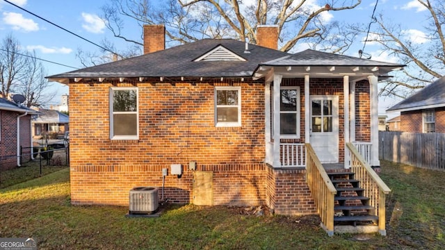 back of house with a lawn and central AC unit