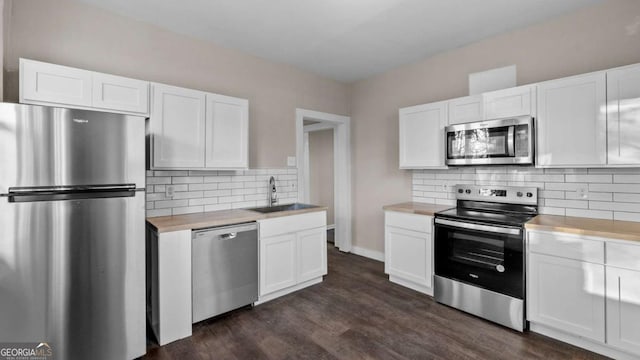 kitchen with sink, white cabinetry, stainless steel appliances, and dark wood-type flooring