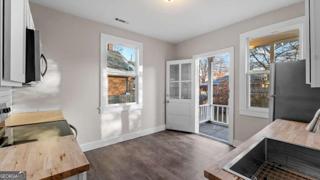 interior space featuring white cabinets, stainless steel fridge, sink, and dark wood-type flooring