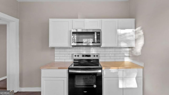 kitchen with white cabinets, appliances with stainless steel finishes, decorative backsplash, and butcher block counters