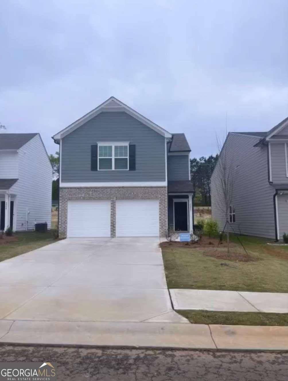 view of front of property featuring a front yard, a garage, and central air condition unit