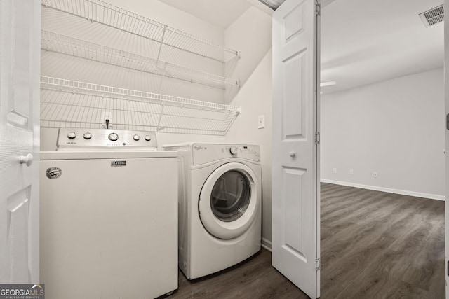 laundry area with washing machine and dryer, laundry area, visible vents, baseboards, and dark wood finished floors