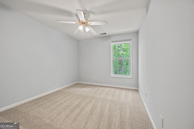 empty room featuring baseboards, visible vents, ceiling fan, and carpet floors