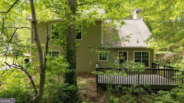 rear view of house with a chimney and a deck