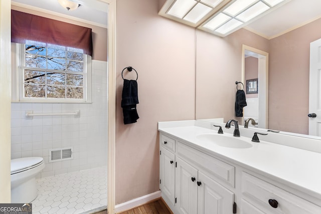 bathroom with vanity, toilet, ornamental molding, and a skylight