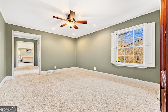 carpeted empty room featuring ceiling fan and ornamental molding