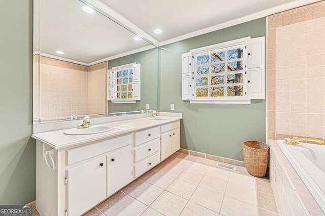 bathroom featuring tile patterned floors, vanity, ornamental molding, and a tub