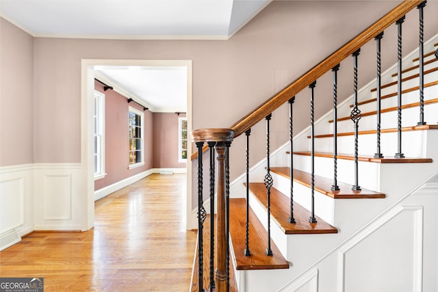 staircase with hardwood / wood-style flooring and crown molding