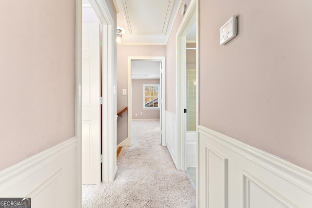 hallway with light colored carpet and crown molding