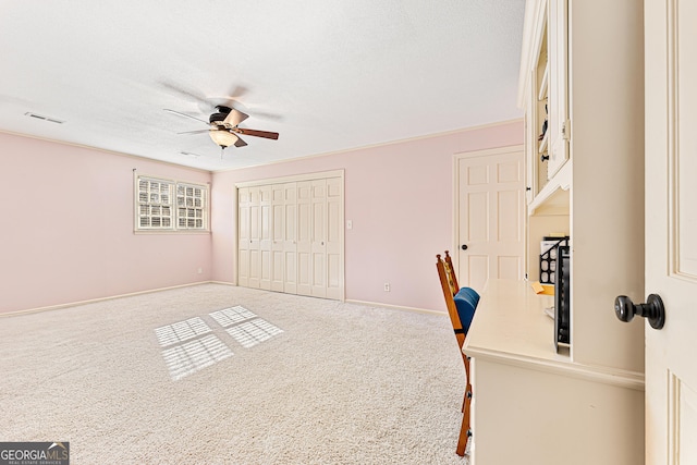 carpeted office featuring ceiling fan