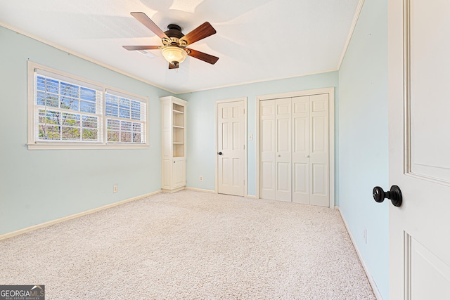 unfurnished bedroom with carpet flooring, ceiling fan, and crown molding