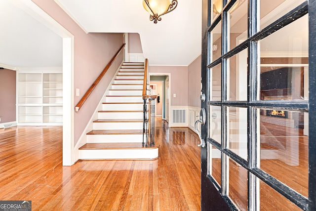 foyer with hardwood / wood-style floors and ornamental molding