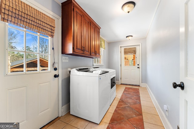 washroom with cabinets, light tile patterned floors, and washing machine and clothes dryer