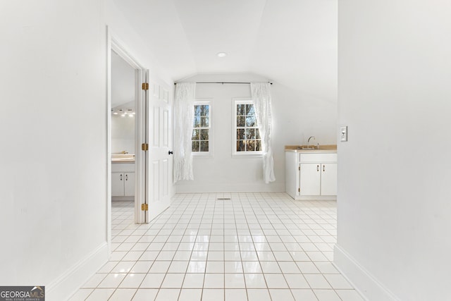 bathroom with tile patterned flooring, vanity, and lofted ceiling