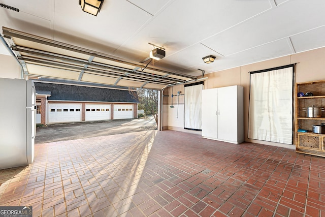 garage with white fridge and a garage door opener