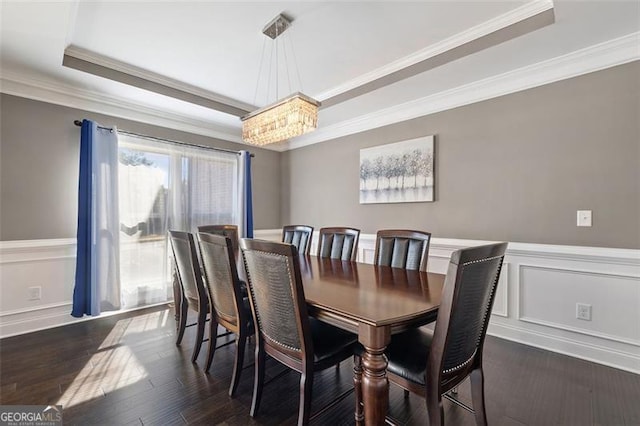 dining space with dark hardwood / wood-style floors, crown molding, a tray ceiling, and an inviting chandelier