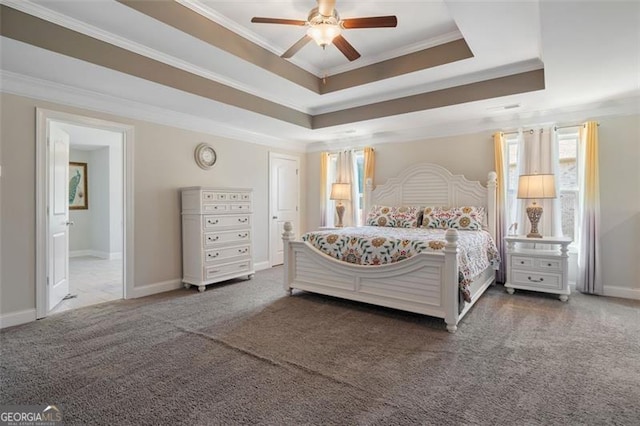 bedroom featuring a tray ceiling, ceiling fan, ornamental molding, and dark colored carpet