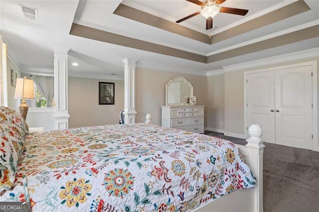 bedroom with ceiling fan, decorative columns, crown molding, and a tray ceiling