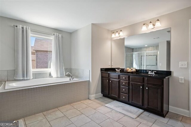 bathroom featuring plus walk in shower, vanity, and tile patterned flooring