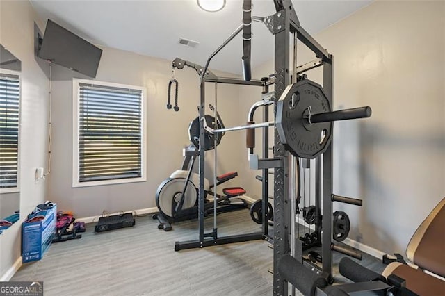 exercise room with light hardwood / wood-style flooring