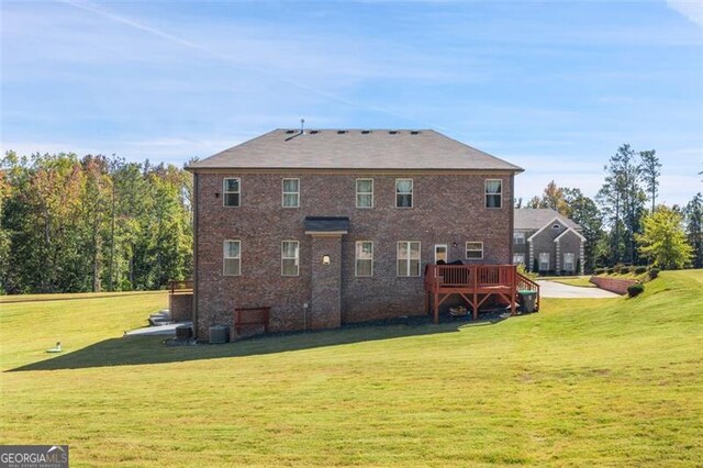 rear view of property with a wooden deck and a lawn