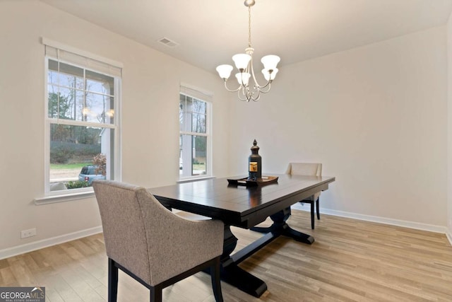 dining room featuring hardwood / wood-style flooring, an inviting chandelier, and a healthy amount of sunlight