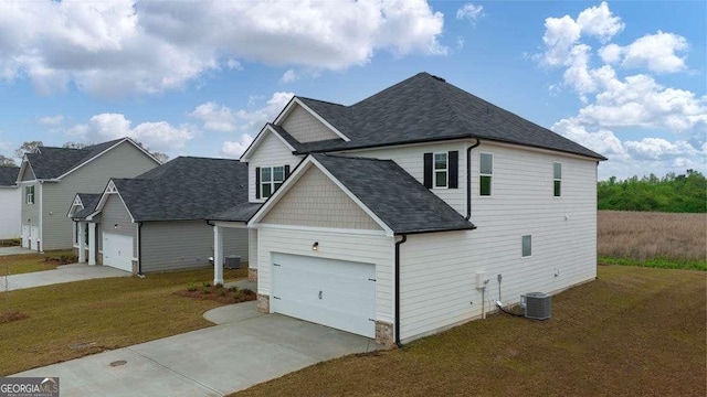 view of side of property with a yard, a garage, and central air condition unit