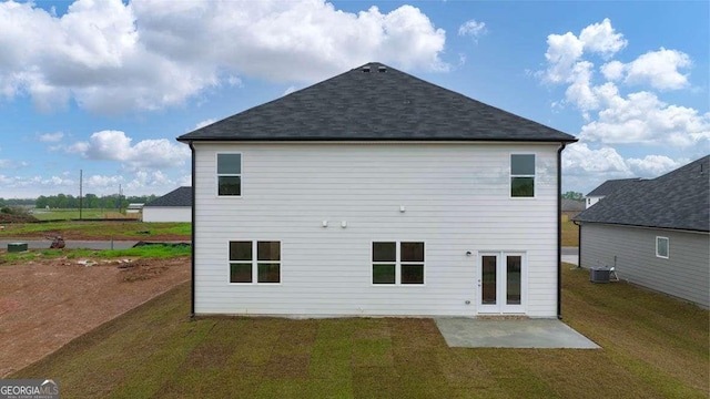 rear view of property featuring a lawn, central AC, and a patio